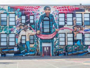 San Francisco Mural: Cesar Chavez Elementary. Man with banner and children doing sign language.