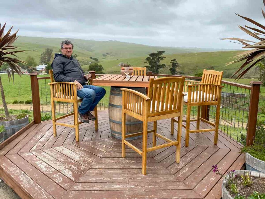 The Deck at Harmony Cellars Winery. Wooden table and chair with pastureland