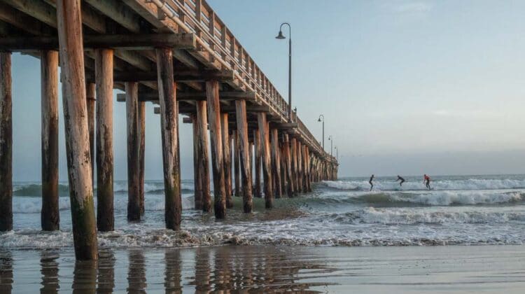 Cayucos beach and pier with surfers at sunset