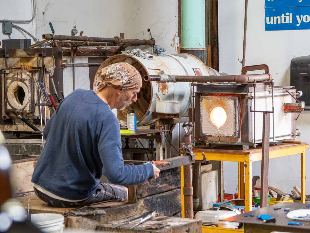 Harmony Glassworks studio. man blowing glass