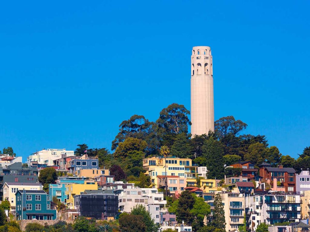 Coit Tower in San Francisco, art deco tower with houses below.